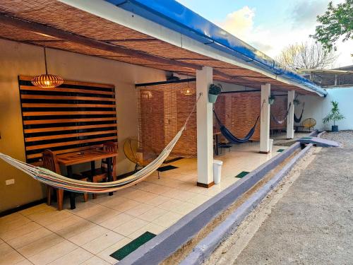 a porch with a hammock and a table at Santa Toro Inn in Santa Teresa Beach