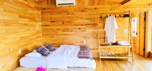 a bedroom with a bed in a wooden wall at Khu sinh thái Ecolodge Kê Nênh Điện Biên in Ban Hin Lom