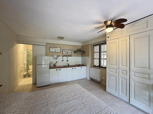 Il comprend une cuisine équipée d'un réfrigérateur blanc et d'un ventilateur de plafond. dans l'établissement Studio pour 2 à Saintes-Maries-de-la-Mer, proche plage et village, jardin calme - FR-1-475-161, à Saintes-Maries-de-la-Mer