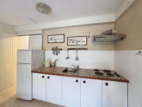une cuisine avec un réfrigérateur blanc et un évier dans l'établissement Studio pour 2 à Saintes-Maries-de-la-Mer, proche plage et village, jardin calme - FR-1-475-161, à Saintes-Maries-de-la-Mer