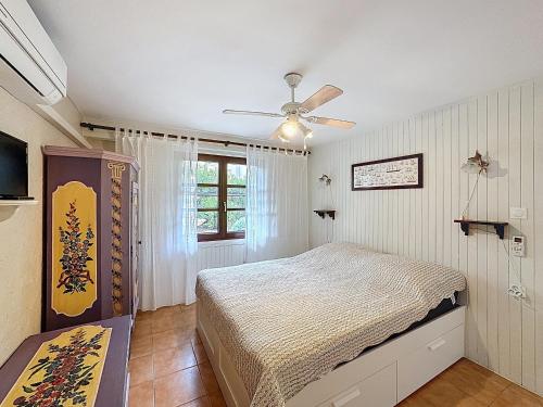 une chambre avec un lit et un ventilateur de plafond dans l'établissement Appartement cosy pour 2, proche plage aux Saintes-Maries-de-la-Mer - FR-1-475-184, à Saintes-Maries-de-la-Mer