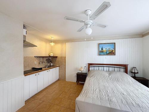 une chambre avec un lit et un ventilateur de plafond dans l'établissement Studio Front de Mer avec Terrasse aux Saintes-Maries-de-la-Mer - FR-1-475-188, à Saintes-Maries-de-la-Mer