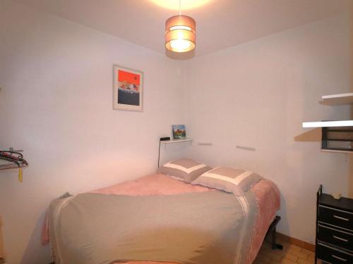 une chambre avec un lit avec deux oreillers dessus dans l'établissement Appartement rez-de-chaussée pour 6 pers, terrasse, proche plage - FR-1-307-286, au Grau-du-Roi
