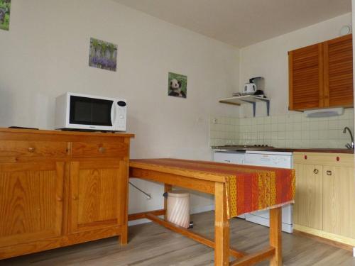une cuisine avec une table et un four micro-ondes. dans l'établissement Studio Cabines 4 Pers - Pied de Piste - FR-1-592-85, à Font-Romeu
