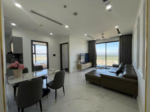 a living room with a couch and a table at Honeymon vinhomes grand park - 3 phòng ngủ in Gò Công