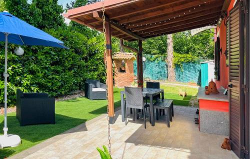 a patio with a table and a blue umbrella at 2 Bedroom Cozy Home In Vasanello in Vasanello