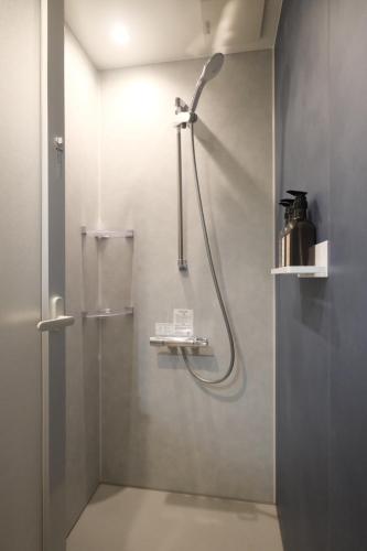 a shower with a shower head in a bathroom at Grand Pia 2, Bentencho in Osaka