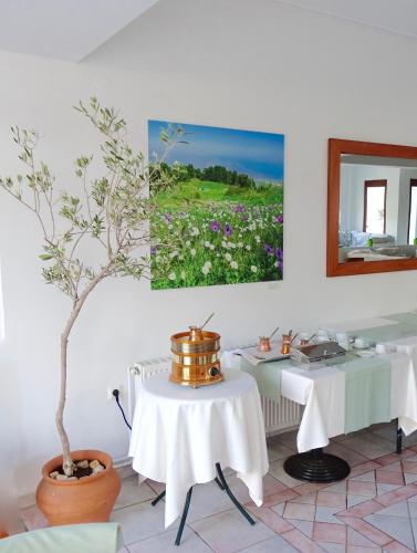 a dining room with two tables and a painting on the wall at Hotel Villa Drosos in Litochoro