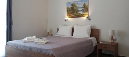 a bedroom with a bed with two towels on it at Sunshine Apartments in Kato Daratso