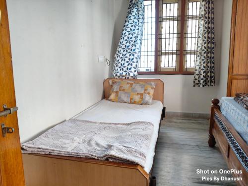 a small bedroom with a bed and a window at Annamaiah Guest House & Homestay - Tirupati - Home Food Service in Tirupati