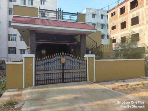 a black gate with a building behind it at Annamaiah Guest House & Homestay - Tirupati - Home Food Service in Tirupati