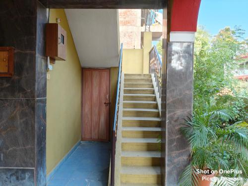 a stairway leading up to a building with a wooden door at Annamaiah Guest House & Homestay - Tirupati - Home Food Service in Tirupati