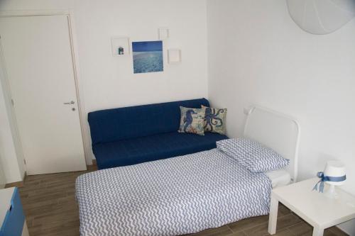 Una sala de estar con un sofá azul y una mesa. en semeria103, en San Remo