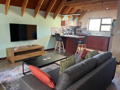 a living room with a couch and a kitchen at Camdeboo Place in Dullstroom