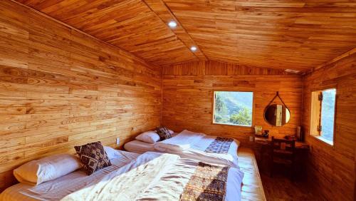 a bedroom with two beds in a wooden cabin at Khu sinh thái Ecolodge Kê Nênh Điện Biên in Ban Hin Lom