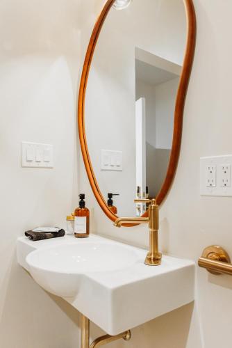 a bathroom with a white sink and a large mirror at Kaleidoscope Inn & Gardens in Nipomo