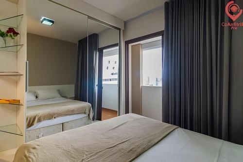 una camera d'albergo con due letti e uno specchio di Studio Moderno | Piscina, Academia, Shopping e +! a Curitiba