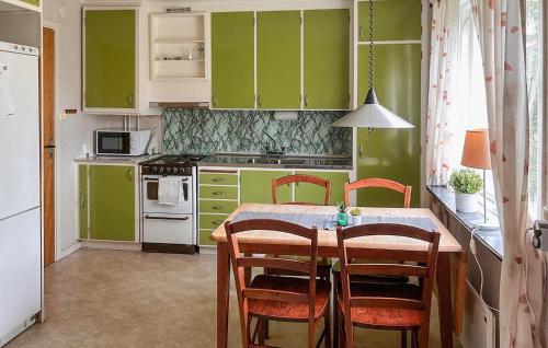 a kitchen with green cabinets and a table with chairs at 1 Bedroom Stunning Home In Fegen in Fegen