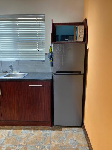 a kitchen with a refrigerator and a microwave on top of it at Camdeboo Place in Dullstroom