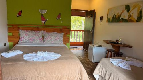 a bedroom with a bed with two towels on it at Pousada Pinhalense in Santo Antônio do Pinhal
