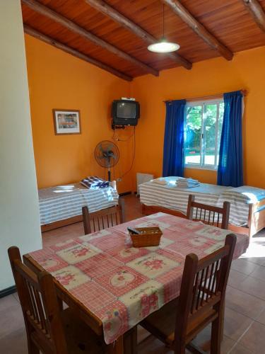 ein Esszimmer mit einem Tisch und 2 Betten in der Unterkunft Bungalows Génesis ideal para las familias a 12 cuadras del parque termal in Federación