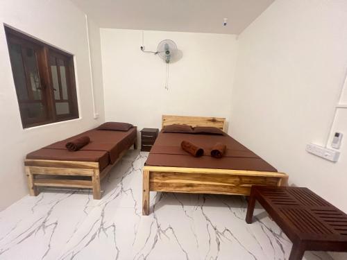 two beds sitting in a room with at The Woodnest in Arugam Bay