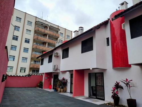 a row of buildings with red shutters on them at Triplex em Caiobá-Matinhos-Pr a 200 mt do mar in Matinhos