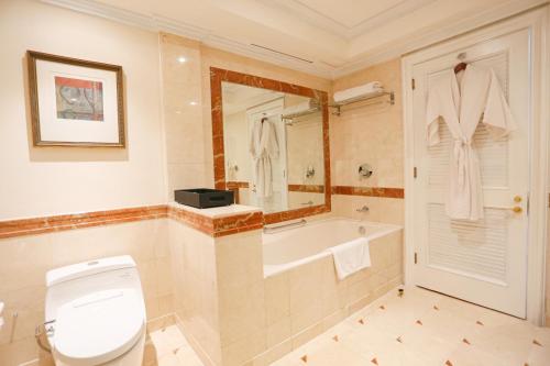 a bathroom with a tub and a toilet and a sink at Wyndham Casablanca Jakarta in Jakarta