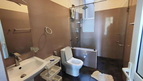 a bathroom with a white toilet and a sink at VIVAS Residencies Luxury Apartments in Colombo