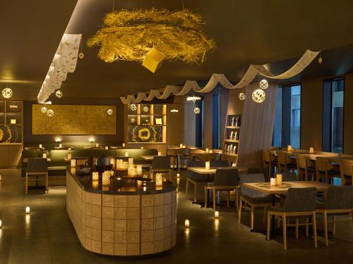 a restaurant with tables and chairs and a bar at OMO5 Kanazawa Katamachi by Hoshino Resorts in Kanazawa
