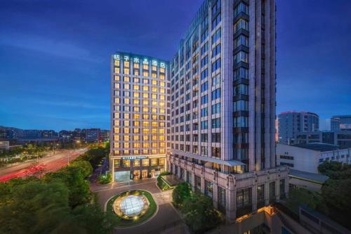 上海市にあるShanghai Changfeng Business District Orange Crystal Hotelの夜の街の高層ビル