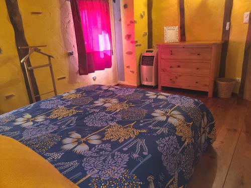 a bedroom with a bed with a blue bedspread with flowers at - - - - -Les Colombages - - - - Chambre d'hôtes-Gîte- Classement Gîte 3 étoiles in Mirepoix