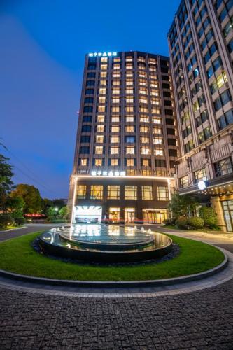 上海市にあるShanghai Changfeng Business District Orange Crystal Hotelの正面に噴水がある大きな建物