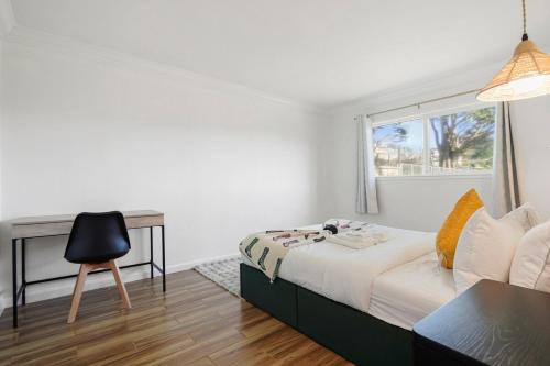 a bedroom with a bed and a desk and a chair at Cozy 2-Bedroom Retreat in Pacifica in Pacifica