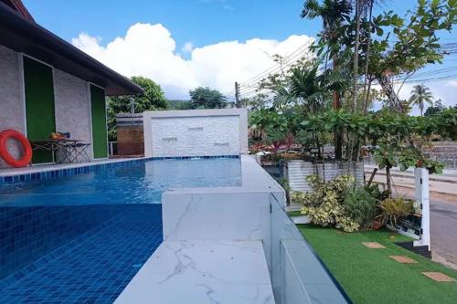 a swimming pool in front of a house at Krabi River Cottage Pool Villa in Ban Krabi Yai