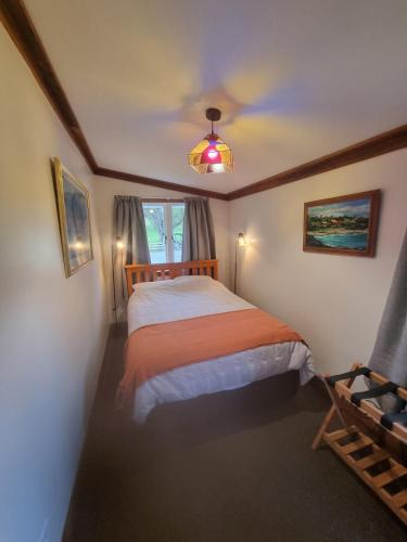 une chambre avec un lit et une fenêtre dans l'établissement Orira River Cottage, à Umawera