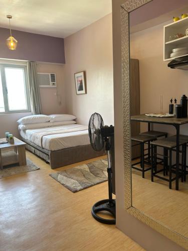 a mirror in a bedroom with a bed and a table at 14F Deluxe Unit at Sunvida Tower across SM CITY in Cebu City