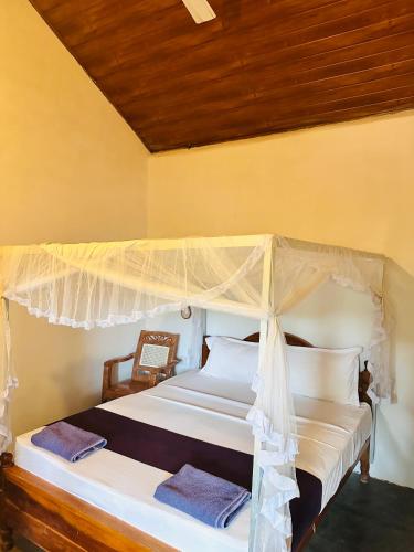 a bedroom with a bed with a canopy at Blue Mountains View in Dambulla