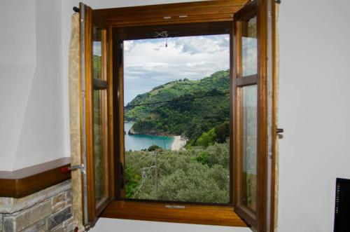 a window with a view of a mountain and a lake at Guesthouse Enastron in Chorefto