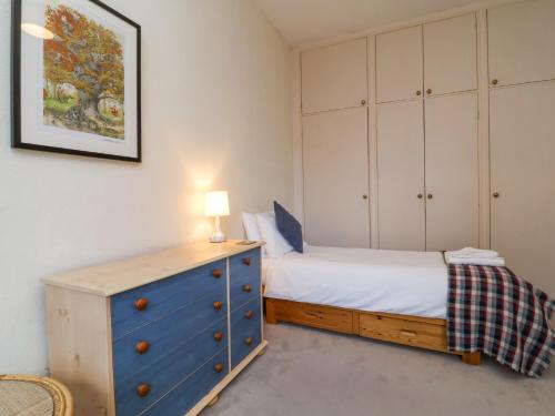 a bedroom with a blue dresser and a bed at The Old Vicarage in Tiverton