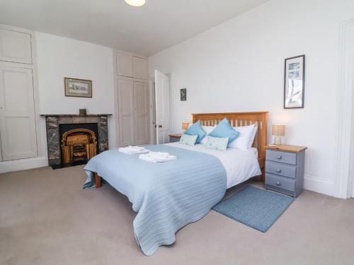 a bedroom with a large bed and a fireplace at The Old Vicarage in Tiverton