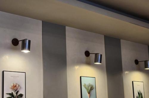 three lights on a wall with pictures on it at Jeju BnB Hotel in Jeju