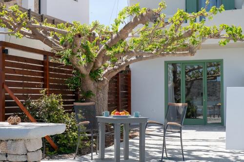 a table and chairs in front of a tree at Christine 2 sea view studio WiFi in Elounda