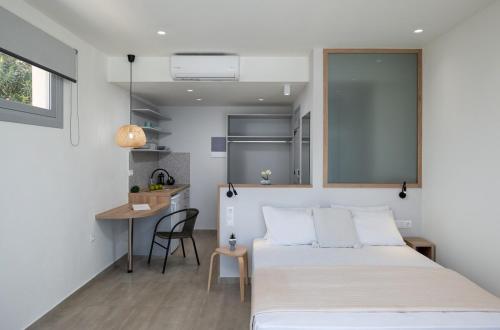 a bedroom with a bed and a table and a desk at Christine 2 sea view studio WiFi in Elounda
