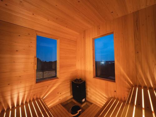 an empty room with two windows in a sauna at Hole 37 in Tsukuba