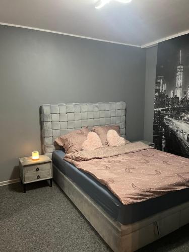 a bedroom with a bed with a large picture on the wall at Odnowiony Apartament Premium in Zawiercie