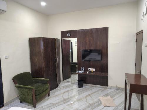 a living room with a chair and a tv on a wall at The Byke Brightland Adventure Park & Resort in Matheran