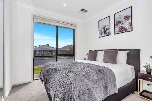 a bedroom with a bed and a large window at Modern Coastal Retreat in Aldinga Beach Just Steps from the Shore in Aldinga Beach