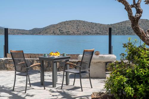 a table and chairs with a view of the water at Christine 2 sea view studio WiFi in Elounda