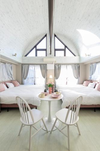 a bedroom with two beds and a table and chairs at UNITEDCUBE STAY TOKYO Private urban vacation home in Tokyo